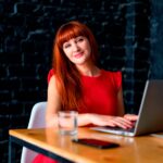 Mulher confiante trabalhando em notebook, simbolizando autonomia profissional