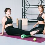 Duas mulheres fazendo exercício de mobilidade e alongamento no tapete